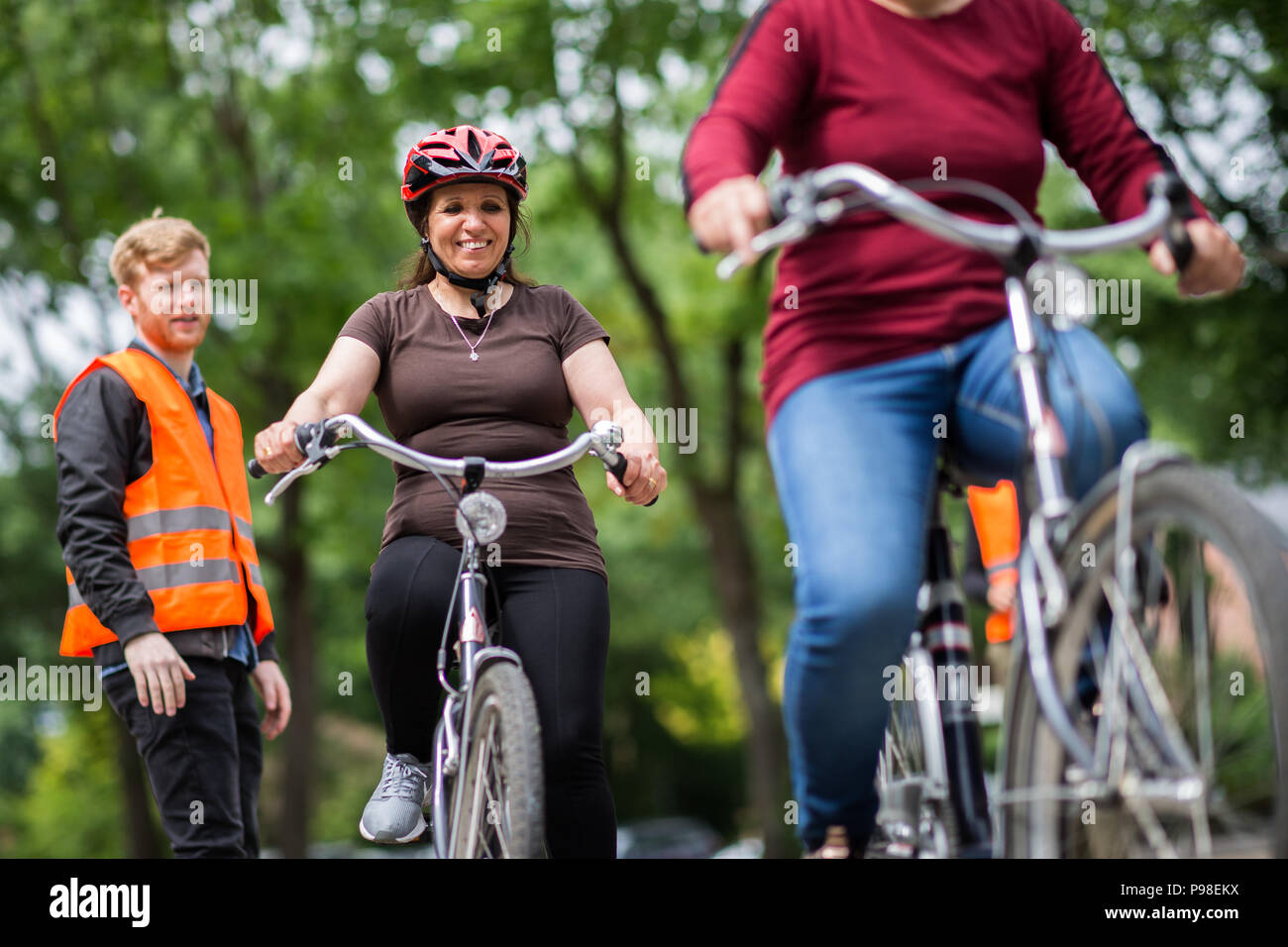 Oldenburg (Germania). Xiii Giugno, 2018. Rasho Zakiya (secondo da sinistra) e gli altri onorevoli a fare pratica con le loro biciclette su una strada tracciata con il gesso sul pavimento presso la scuola di ciclismo per adulti. Istruttore Christian Capelle (L) guarda a. Credito: Mohssen Assanimoghaddam/dpa/Alamy Live News Foto Stock