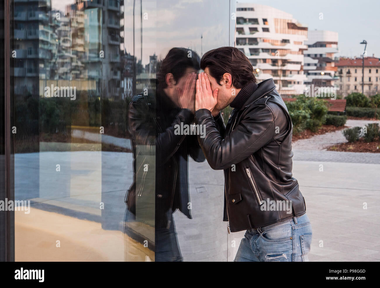 Uomo informale alla ricerca all'interno della finestra Foto Stock