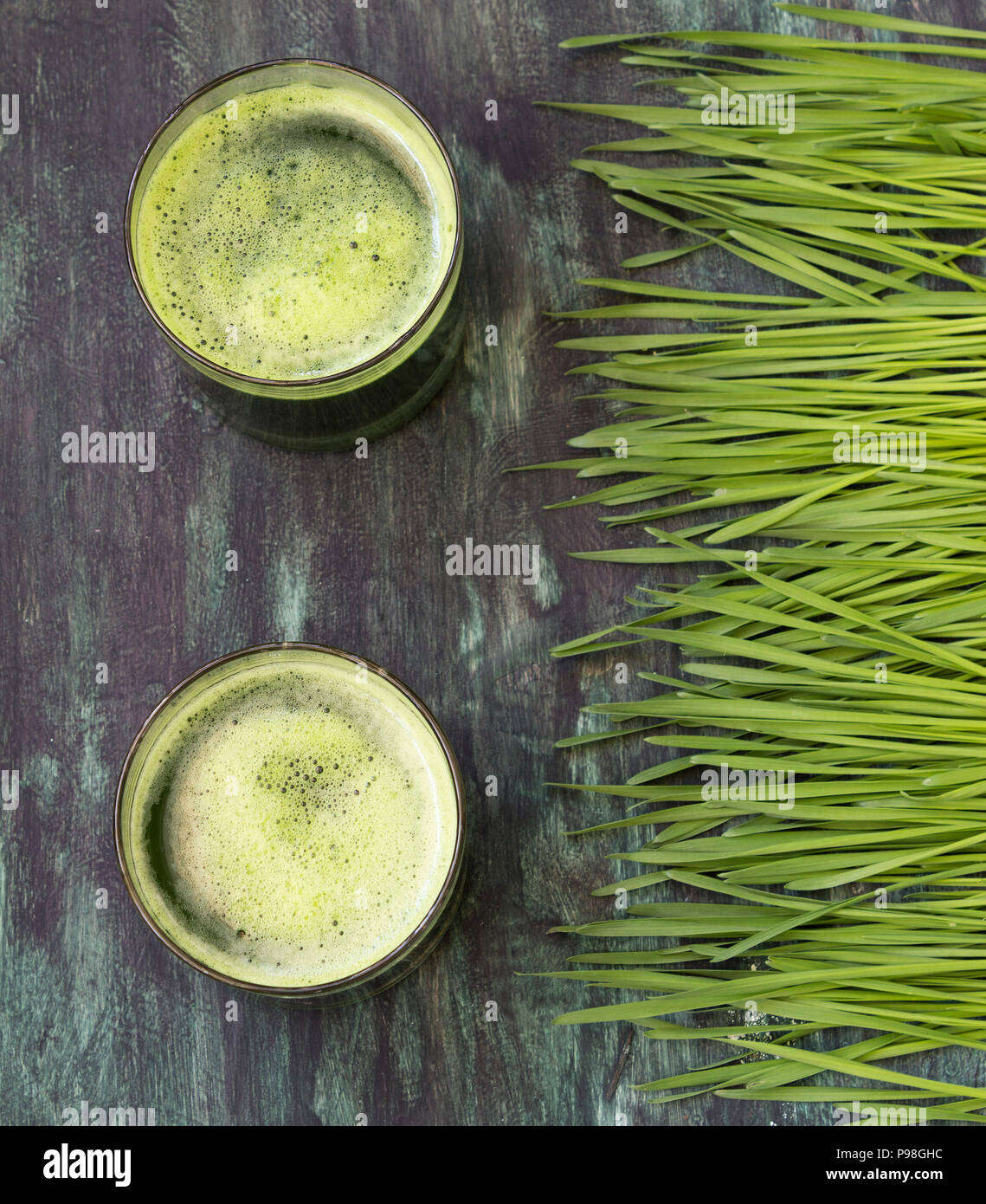 Wheatgrass e bicchiere di succo verde- overhead shot Foto Stock