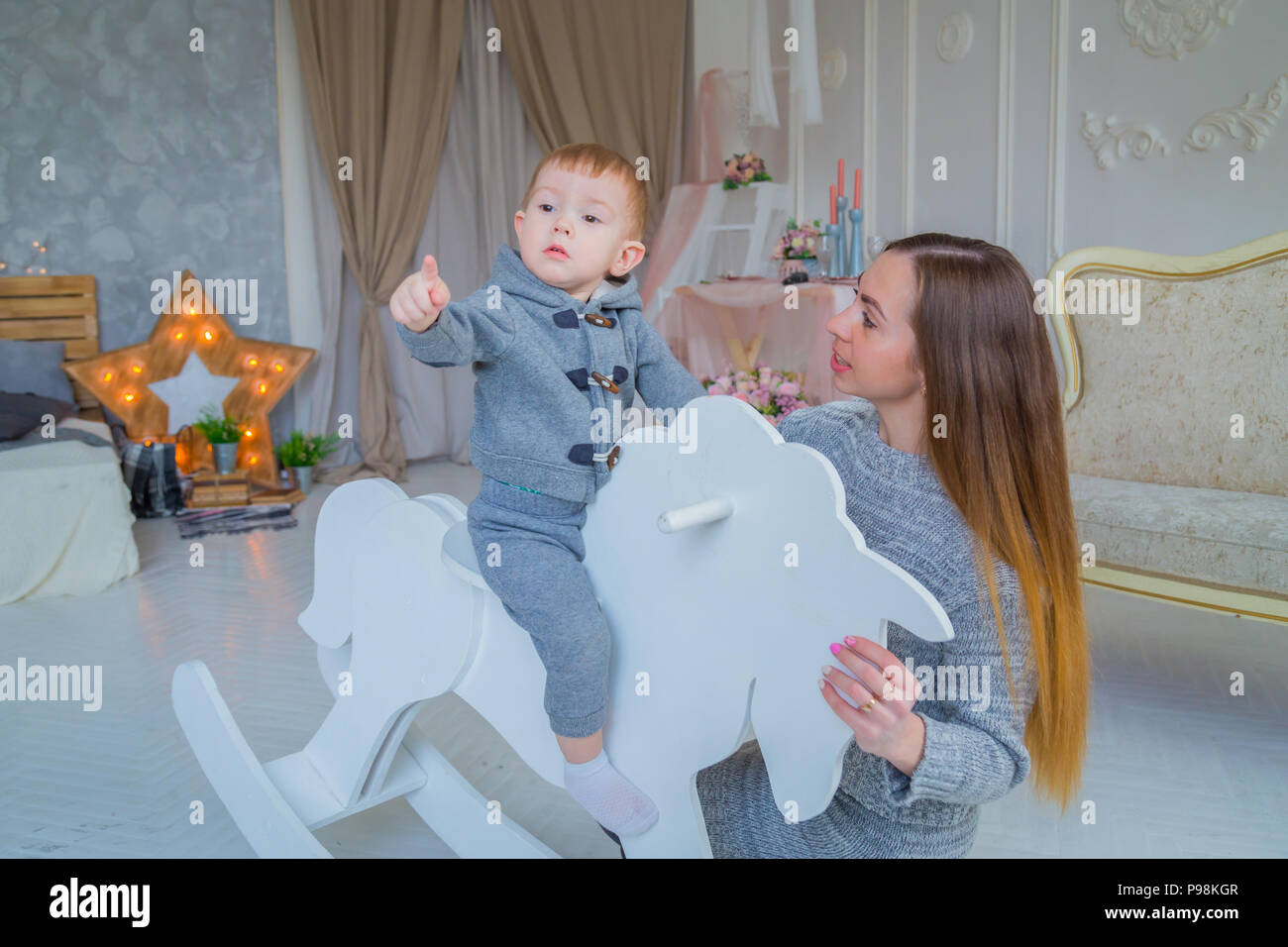 Little Boy giocando su legno cavallo a dondolo Foto Stock