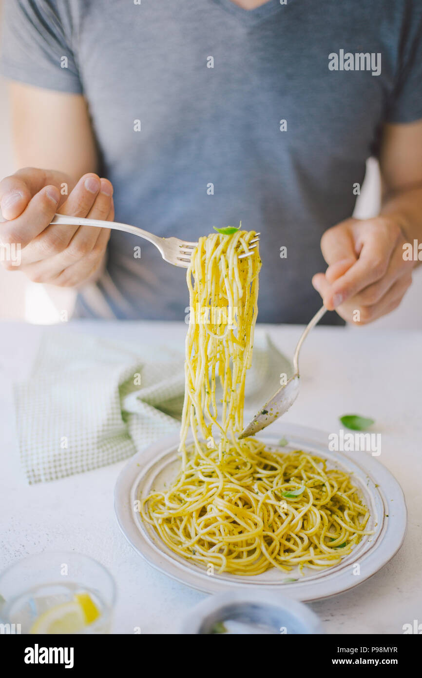 Giovane uomo mangiare gustosi piatti di pasta italiana. Mangiare sano concetto Foto Stock