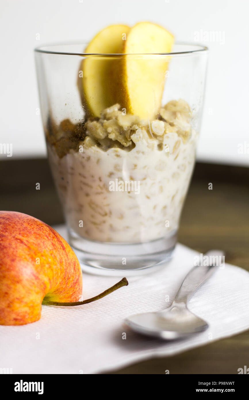 Il Porridge salute sano prima colazione pasto vegano mangiare pulito Apple cucchiaio sullo sfondo di legno Foto Stock