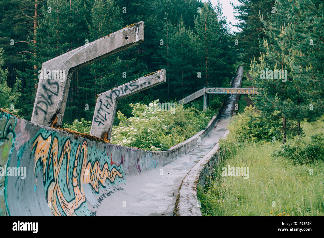 Ora il calcestruzzo in disuso del 1984 Sarajevo Olympic di bob e slittino curve traccia attraverso la foresta, coperto di graffiti Foto Stock
