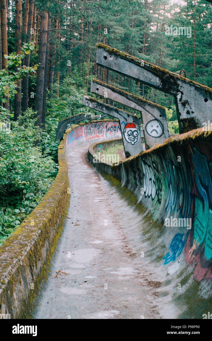 Ora il calcestruzzo in disuso del 1984 Sarajevo Olympic di bob e slittino curve traccia attraverso la foresta, coperto di graffiti Foto Stock