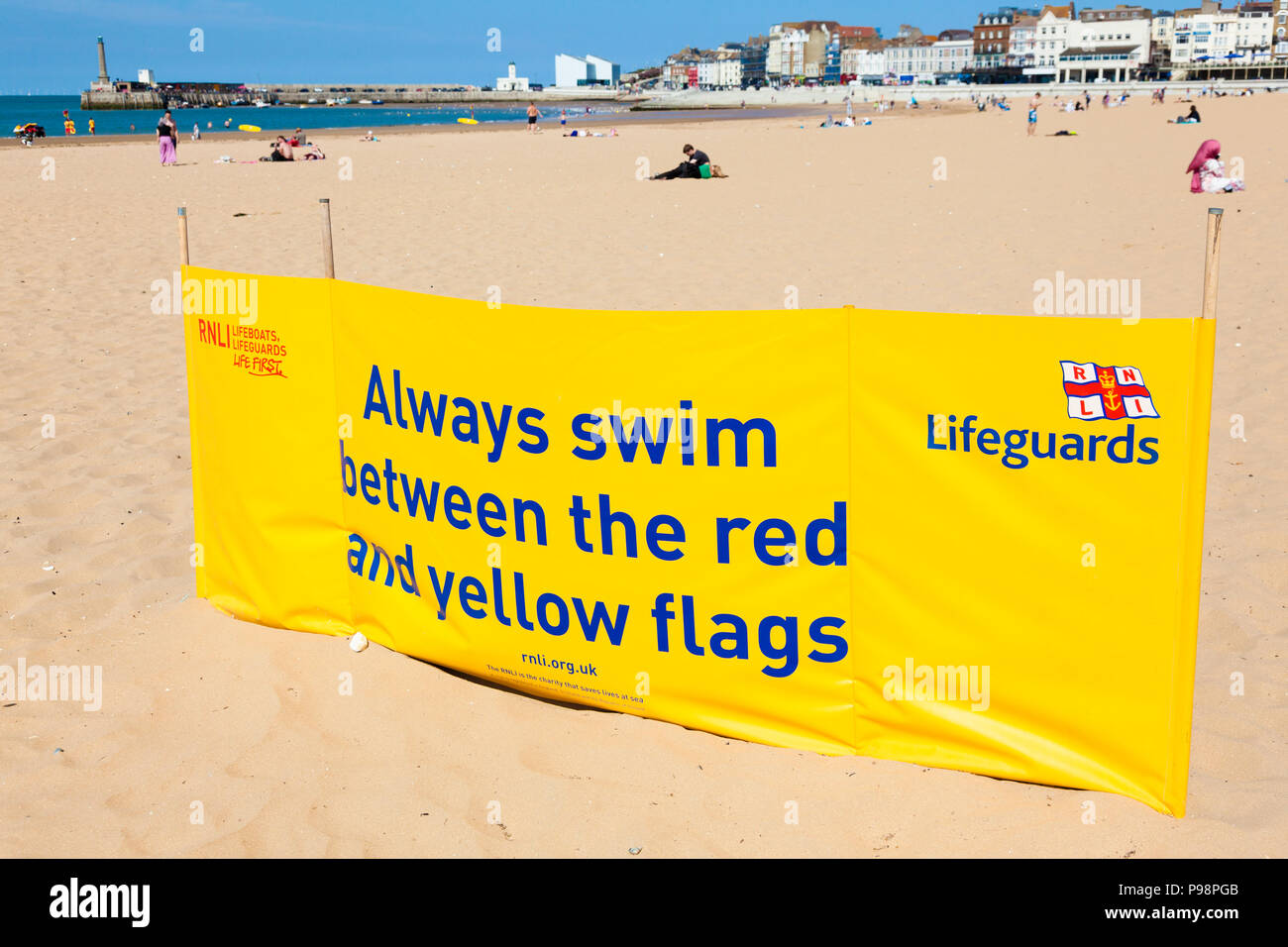Bagnini RNLI sicuro segno di nuoto sulla spiaggia a Margate, Kent, Regno Unito, d'estate. Foto Stock