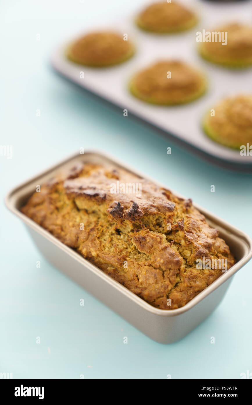 Pane appena sfornato la torta di carote e muffin in vassoi da forno. Sfondo blu, ad alta risoluzione Foto Stock