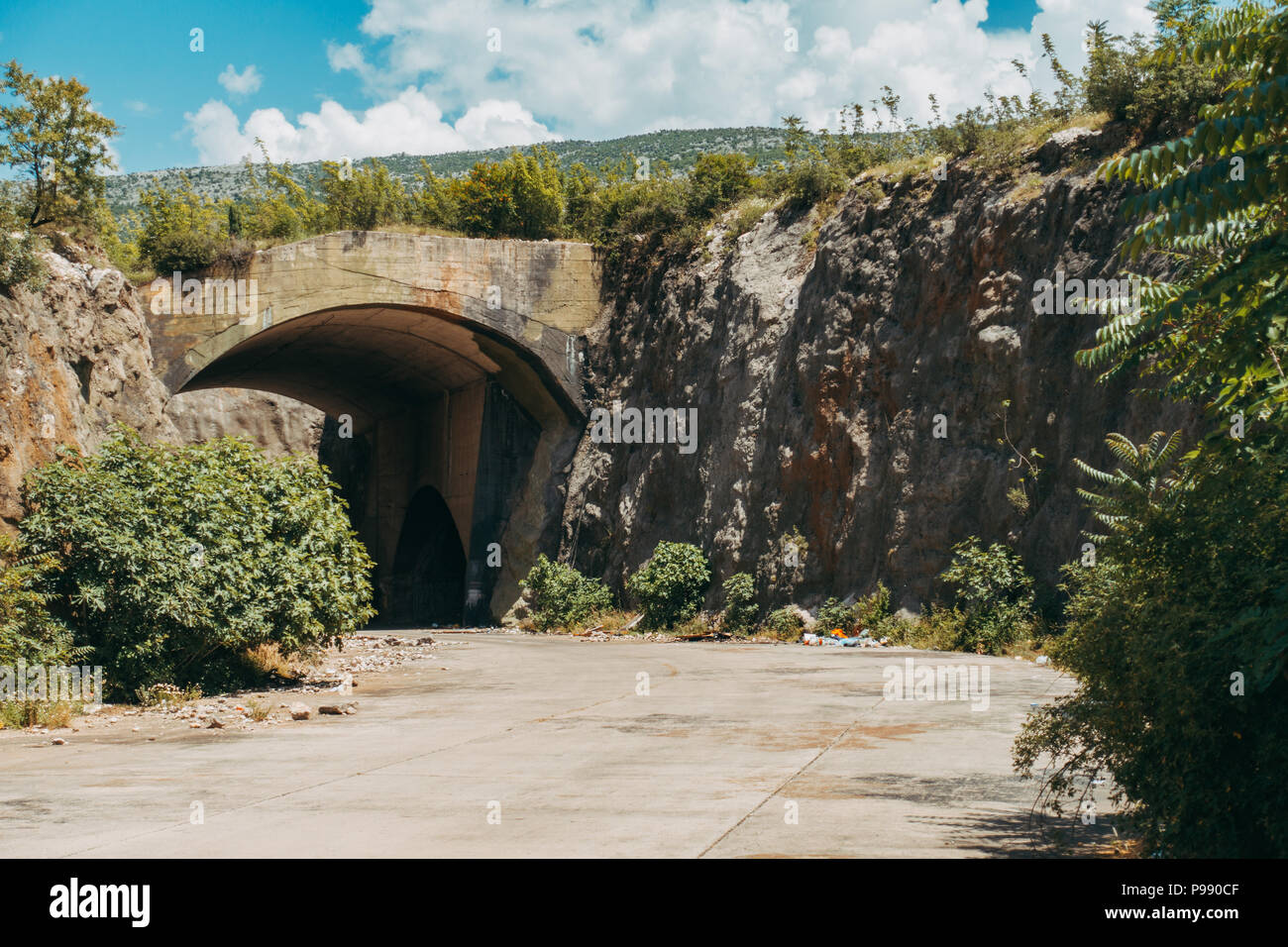Un hangar abbandonati all aeroporto di Mostar, la BiH. Durante la guerra di Bosnia, fino a un massimo di 10 aerei da combattimento sono stati alloggiati in qui, protetto da montagna Foto Stock