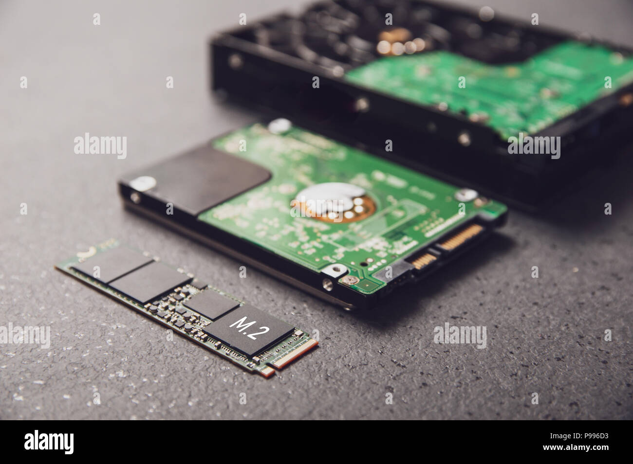 Unità disposte su un tavolo di pietra che simboleggia lo sviluppo della tecnologia da HDD a SSD Foto Stock