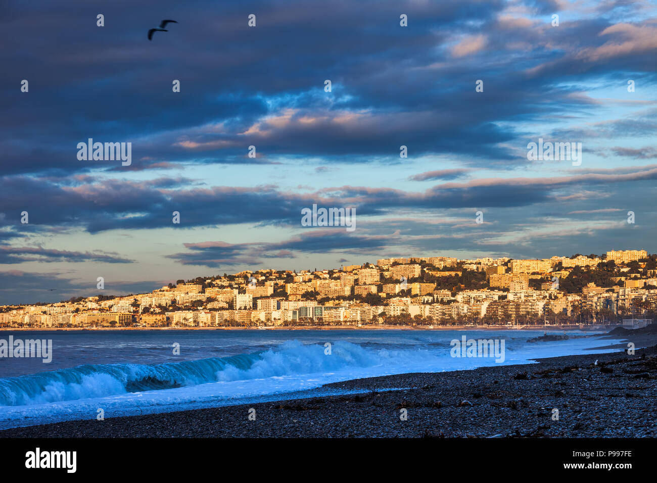 Skyline della città di Nizza a sunrise in Francia, vista dalla Costa Azzurra spiaggia al mare Mediterraneo Foto Stock