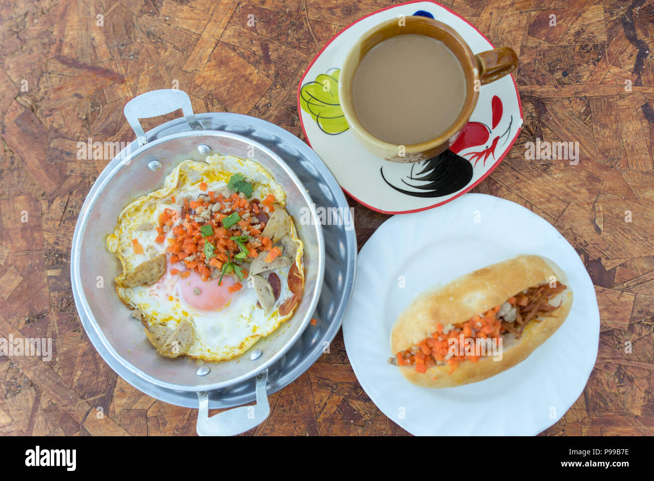 Nord-est colazione tailandese con caffè, padella calda uovo fritto farcite con carne macinata di maiale e salsiccia, comuni anche per il vietnamita e il Laos persone Foto Stock