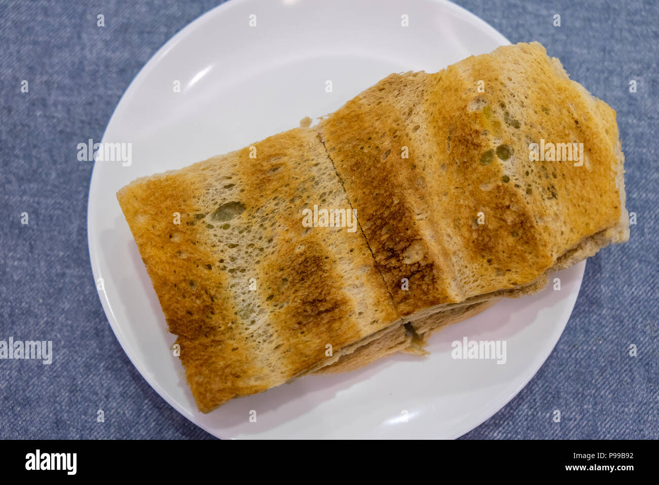 Tradizionale colazione Singapore chiamato Kaya toast, pane di cocco con marmellata e burro, il fuoco selettivo tecnica Foto Stock