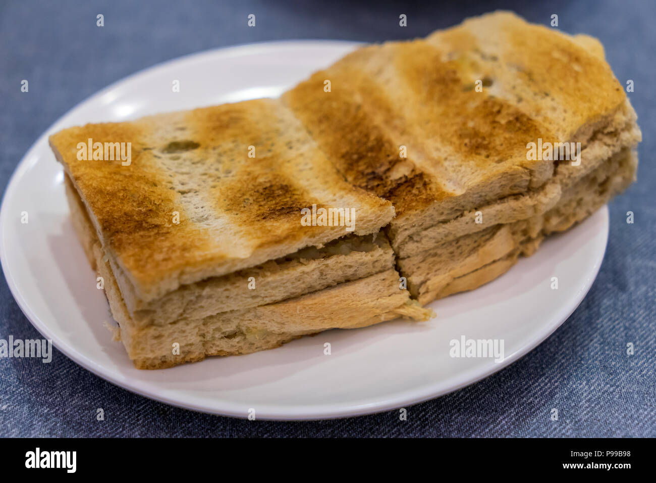Tradizionale colazione Singapore chiamato Kaya toast, pane di cocco con marmellata e burro, il fuoco selettivo tecnica Foto Stock