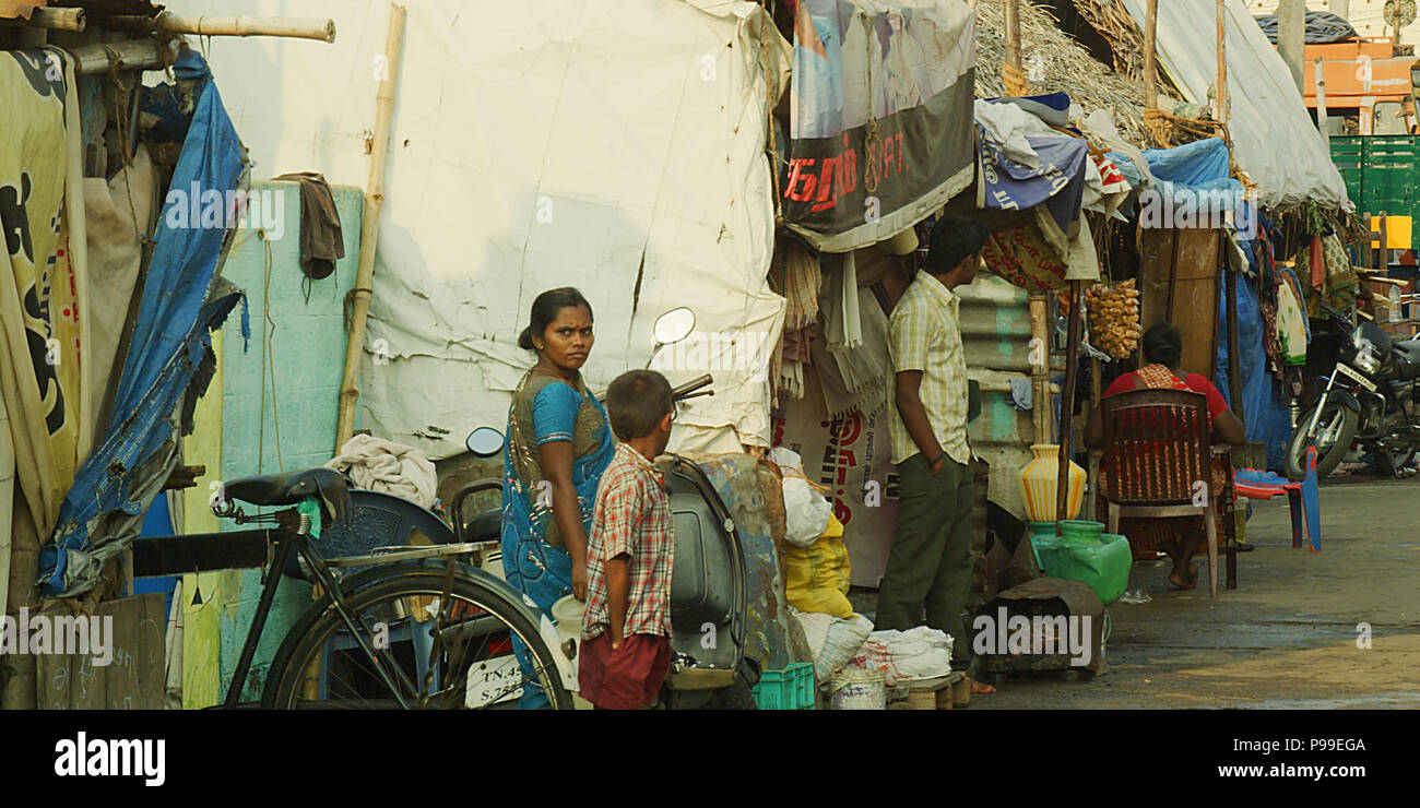 Unidentified poveri vicino alle loro case in baraccopoli in India. Foto Stock