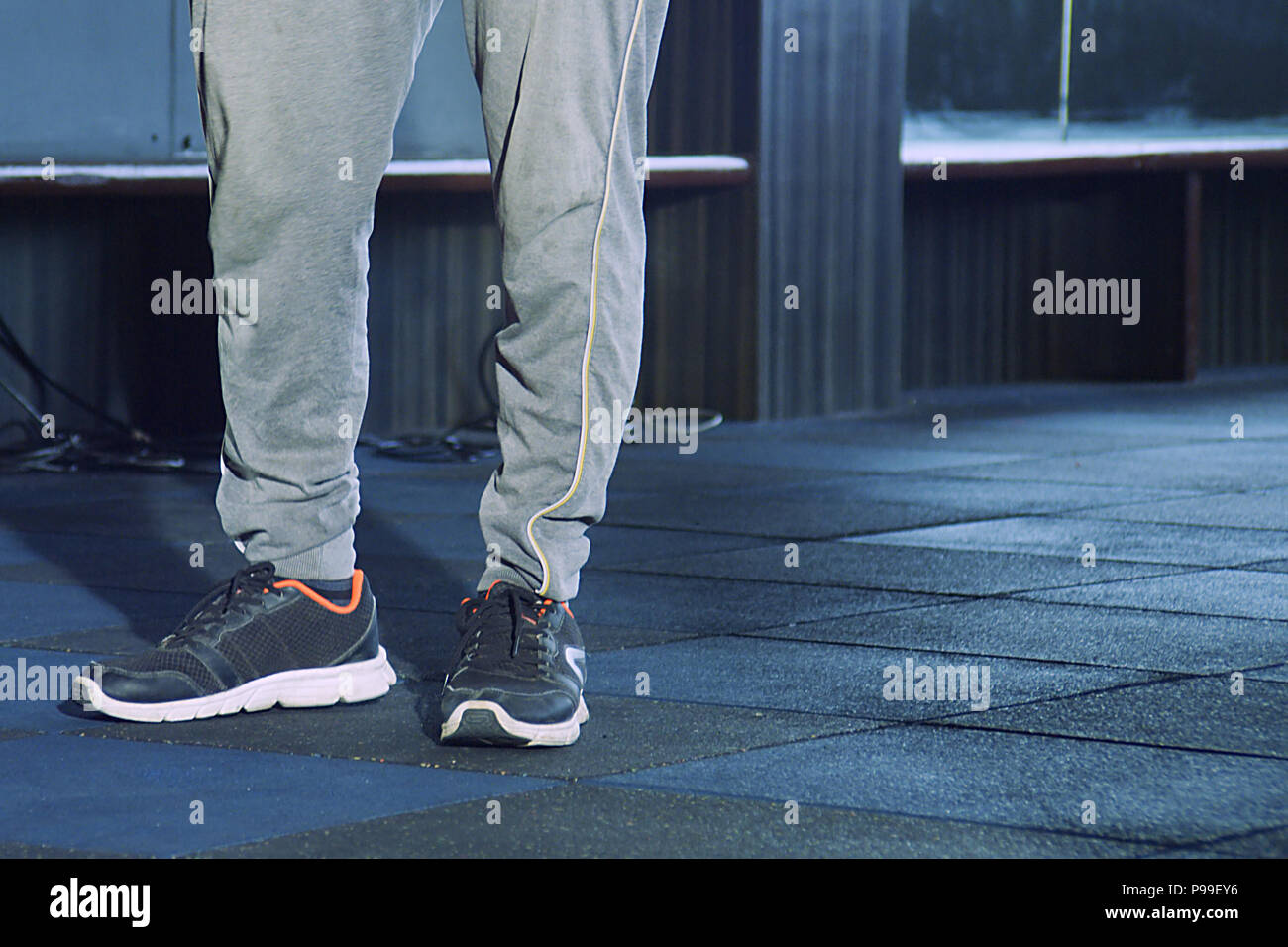 Moda giovane uomo per le gambe e le scarpe sul pavimento di legno, l'uomo è  in posa in palestra Foto stock - Alamy