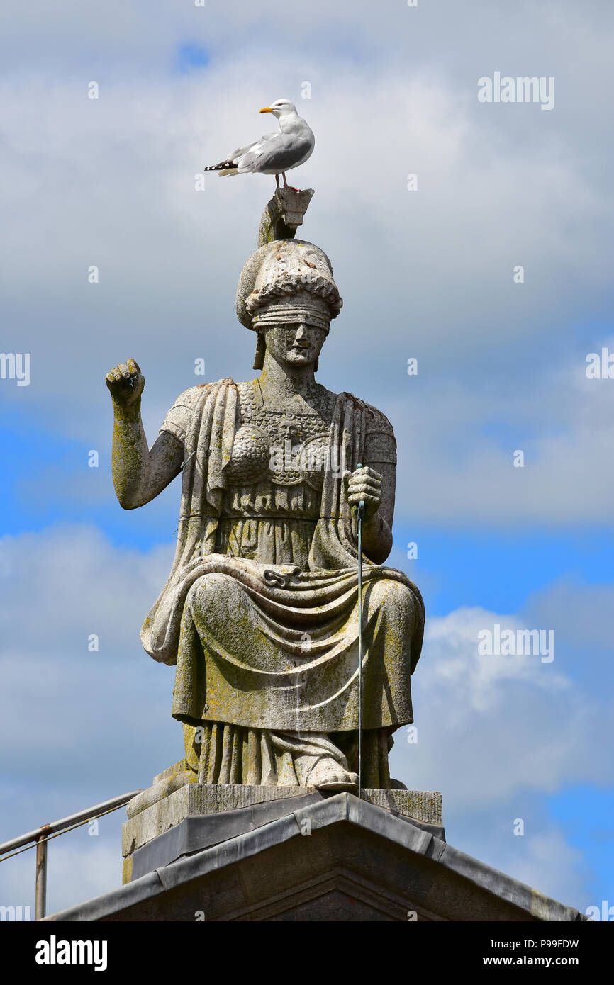 Vista della Britannia statua sulla sommità del Municipio in Castello di Fossato da Caernarfon Castle, Caernarfon Galles del Nord Foto Stock