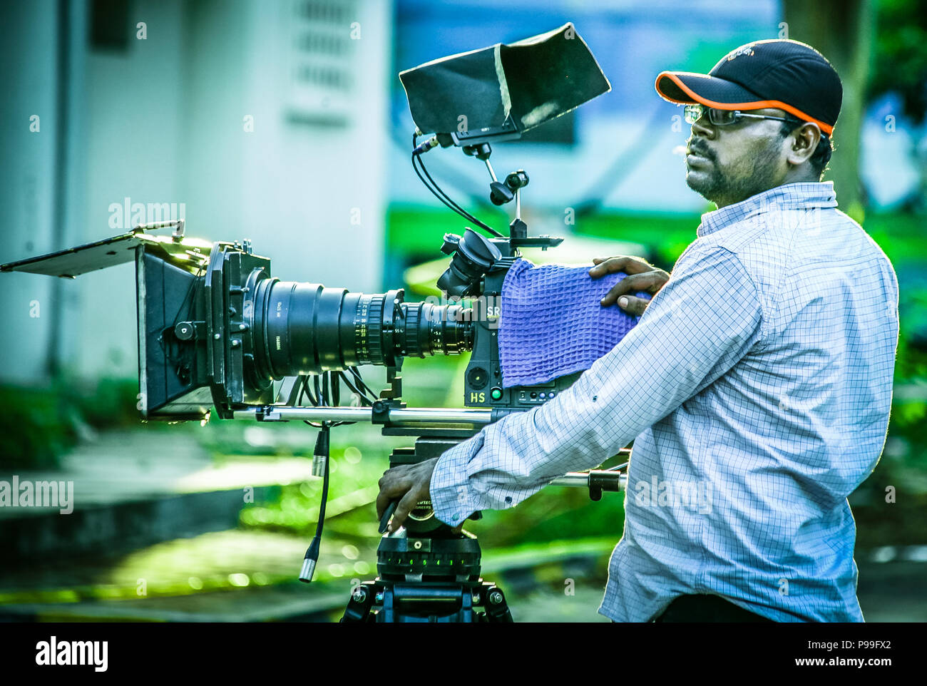 Cameraman per le riprese dei film scena con la sua fotocamera sulla posizione esterna Foto Stock