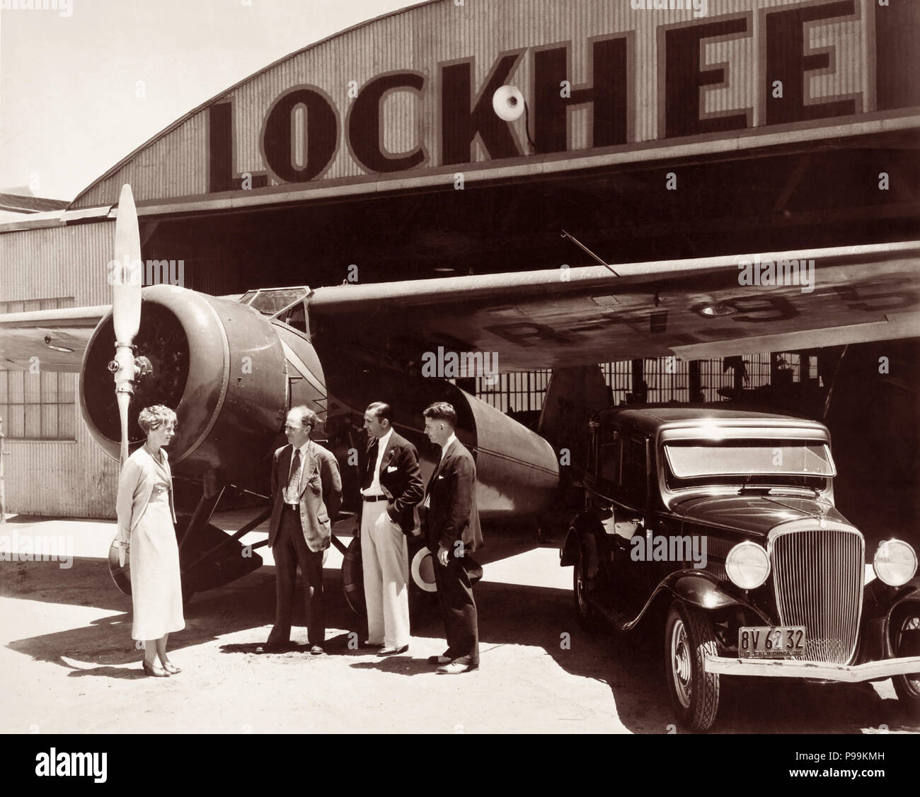 Amelia Earhart con Allen Lockheed, Carl Squier e Floyd vapore a Lockheed di hangar di Burbank, in California, in piedi accanto al Lockheed Vega 5B in cui Earhart divenne la prima donna a completare un solo volo transatlantico del 21 maggio 1932. (Foto: 1932) Foto Stock