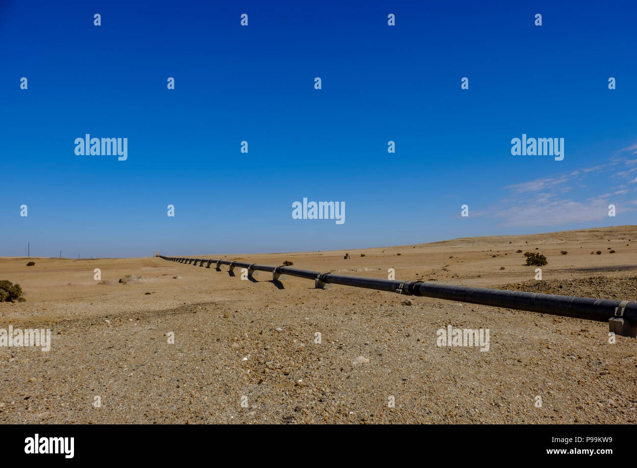 Remote deserto del Namib con sopra la terra tubo di ferro che si estende su per trasportare acqua da impianto di desalinizzazione di Swakopmund alla miniera di uranio. Costruito con chi Foto Stock