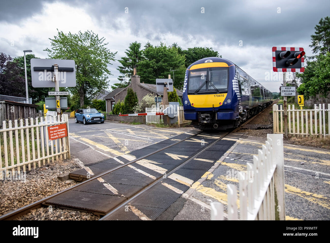 Il treno al passaggio a livello Foto Stock