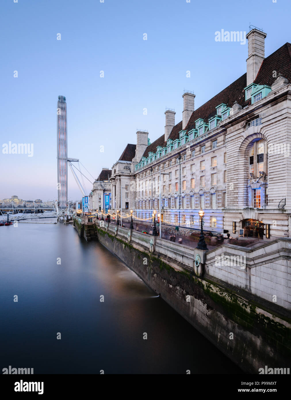 Una lunga esposizione vista verticale della Coca-Cola, il London Eye e la County Hall dal Westminster Bridge, Londra, prese al tramonto con un cielo blu chiaro Foto Stock
