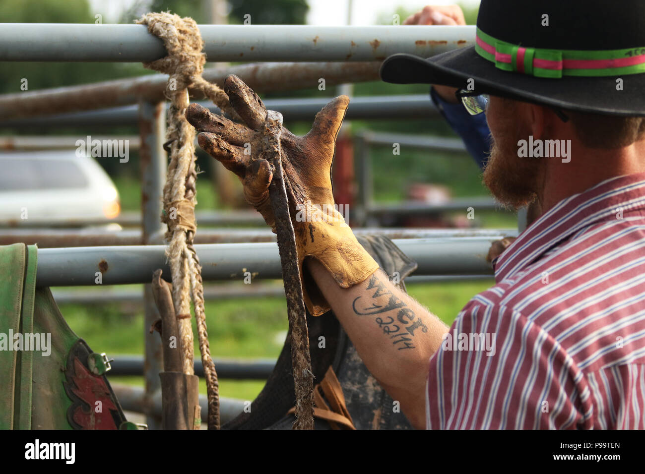 Bull pilota applica controlli e colofonia sul suo guanto di equitazione. Piccola città settimanale di toro di equitazione come sport. Fox Hollow Rodeo. Waynesville, Dayton, Ohio, USA Foto Stock