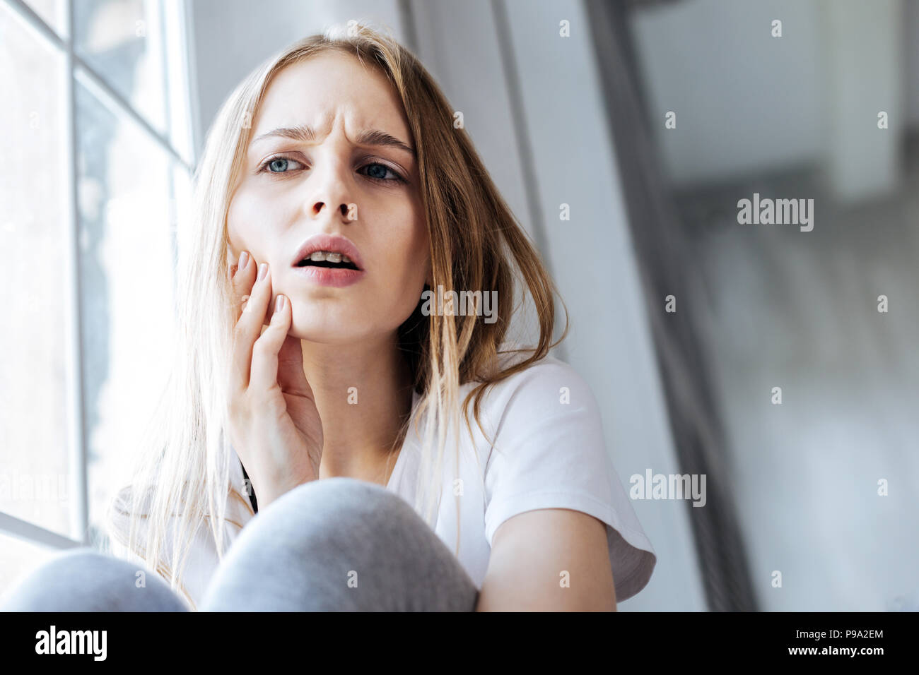 Preoccupato ragazza avente un terribile mal di denti Foto Stock