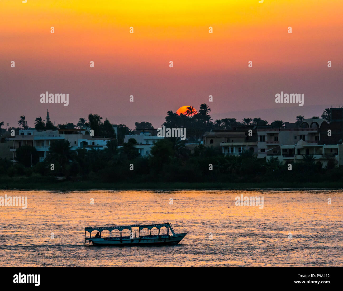 Colorato tramonto sul fiume Nilo, con battello fluviale silhouette, Luxor, Egitto, Africa Foto Stock