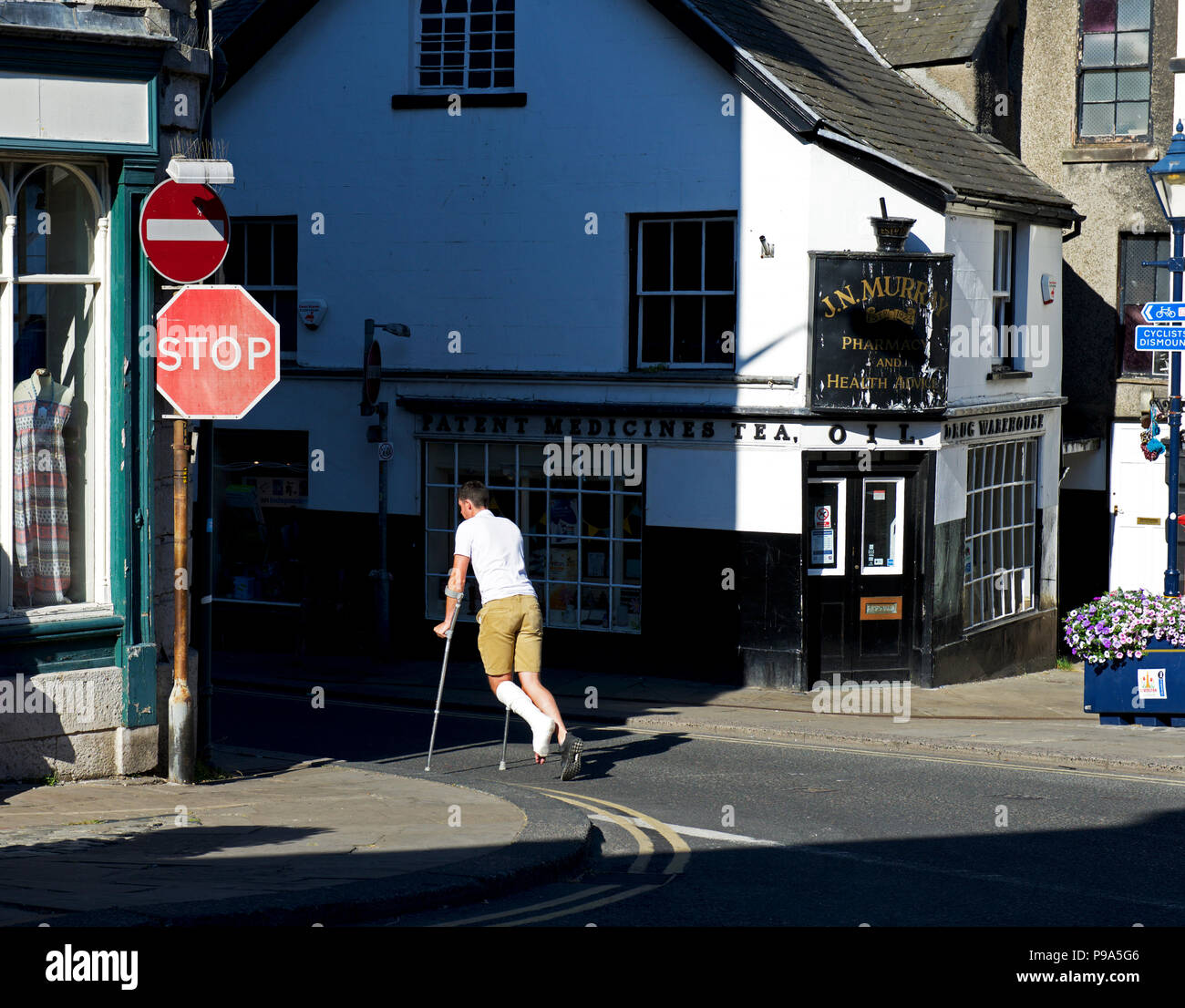 Giovane uomo su cutches, con piede nel calco in gesso, Ulverston, Cumbria, Regno Unito Inghilterra Foto Stock