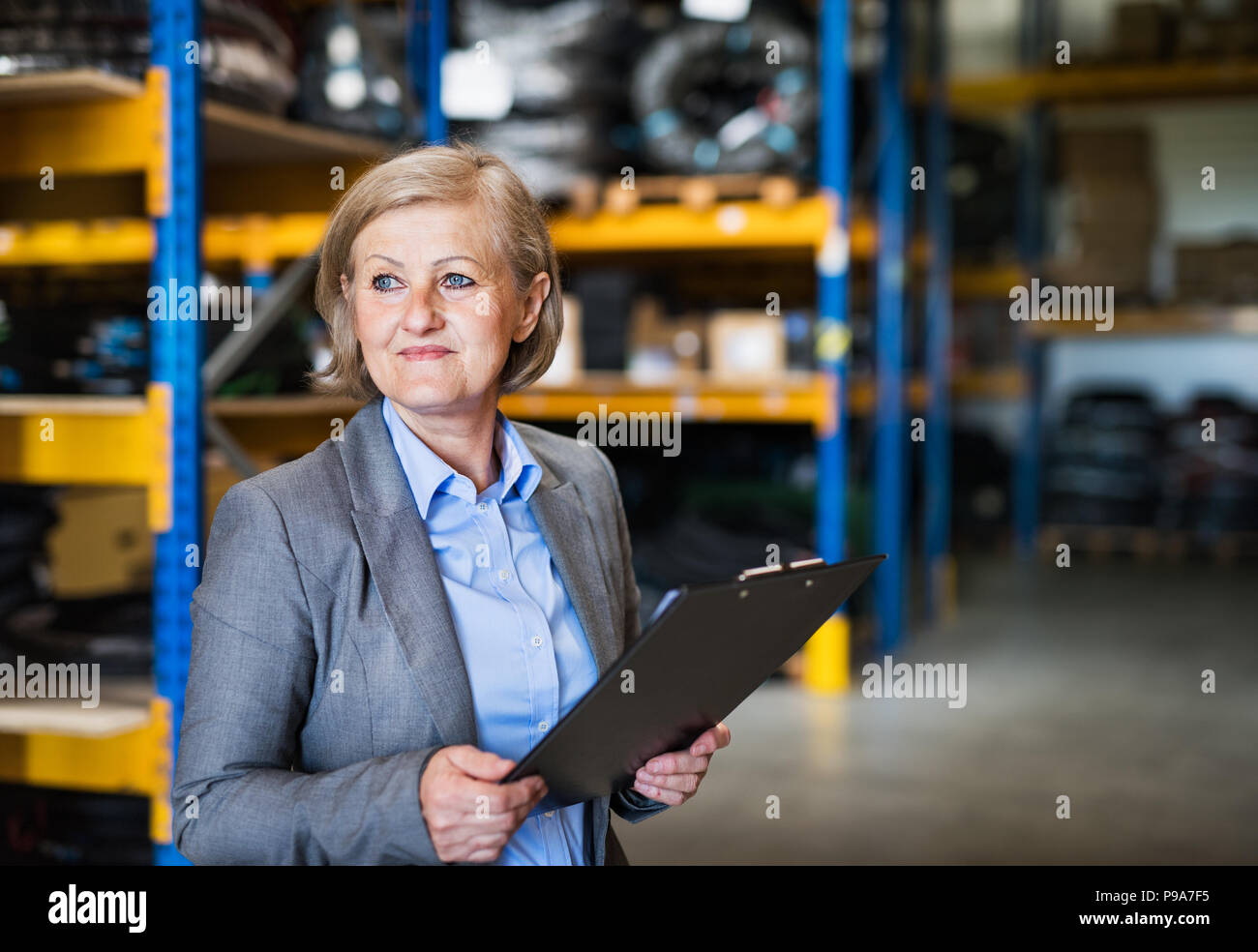 Senior donna warehouse manager o supervisore con appunti. Foto Stock