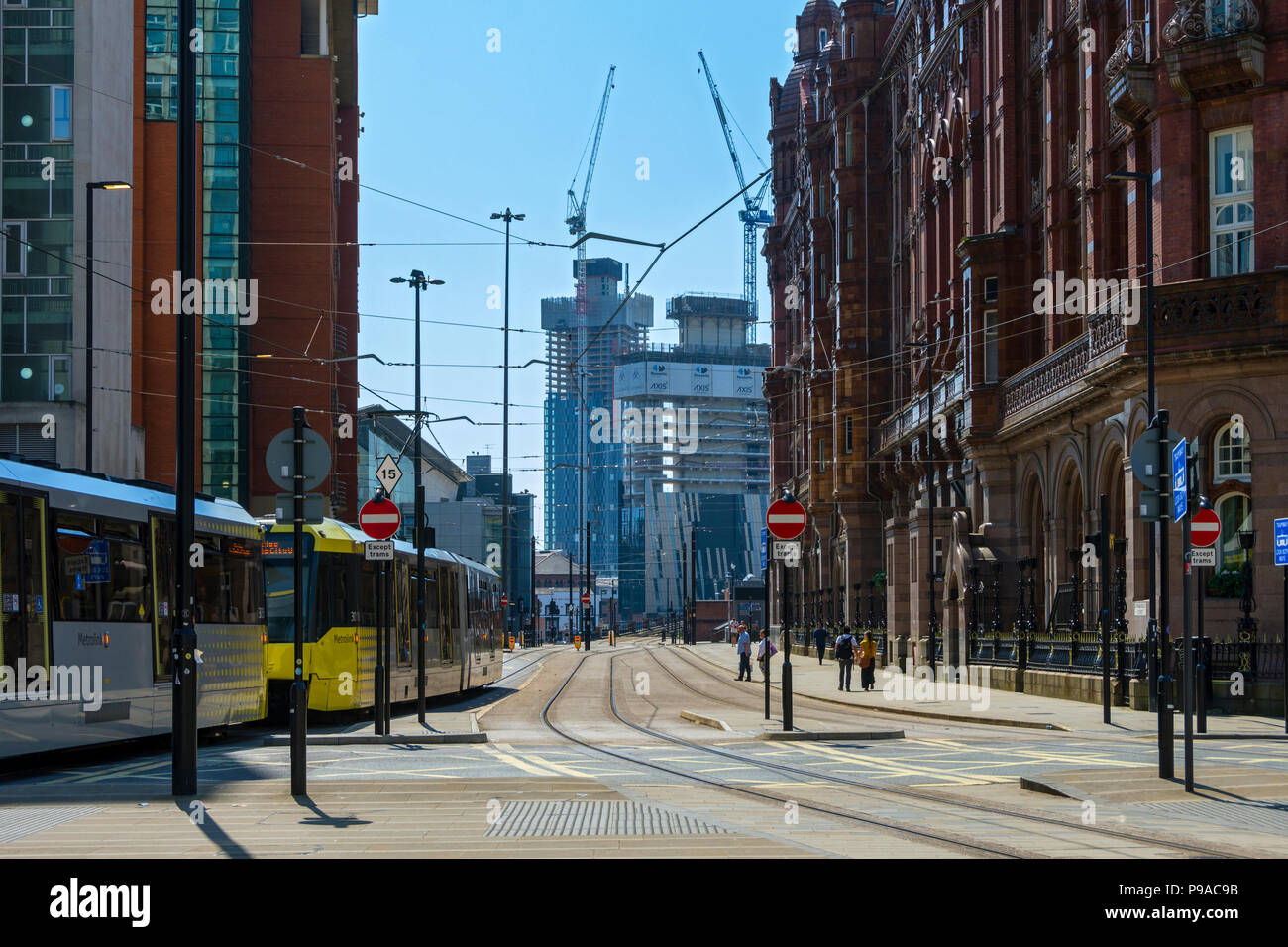 L'asse e Deansgate Square Appartamento blocchi (in costruzione) con un tram Metrolink passando il Midland Hotel, inferiore Mosley San, Manchester, Regno Unito Foto Stock