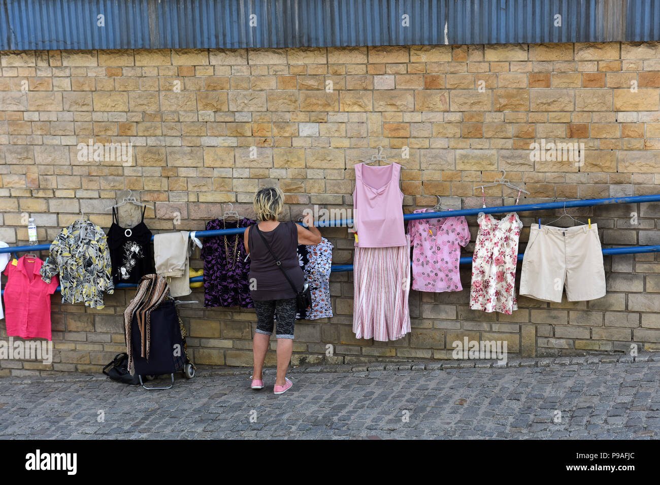 Commerciante di strada che vende vestiti sulla ringhiera Wrocław Polonia Foto Stock