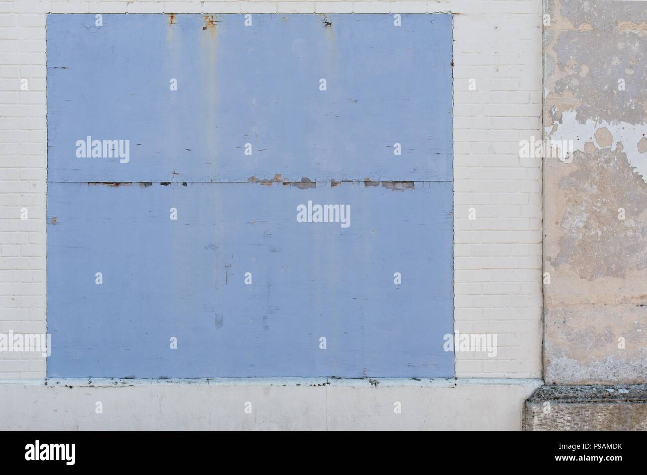 Whitwashed vecchio muro in mattoni con blue borded up Foto Stock