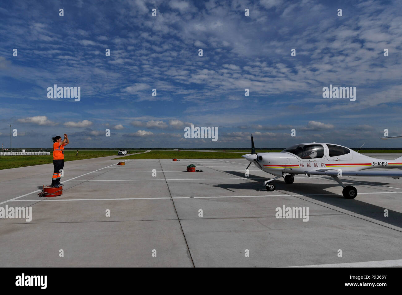 Songyuan, la Cina della provincia di Jilin. 17 Luglio, 2018. Deng Yun guide di un aeromobile a un determinato luogo presso il lago Chagan aeroporto di Songyuan, a nord-est della Cina di provincia di Jilin, 17 luglio 2018. Deng nasce nel 1991. Ella è un aereo addetto alla manutenzione di un Aviation Academy di Jilin. Il giovane ingegnere femmina e gli altri nove colleghi sono responsabili della formazione di manutenzione piano all'aeroporto. Per garantire la sicurezza del volo, di cui hanno bisogno per verificare la presenza di più di cento articoli prima di un aereo decolla. Credito: Zhang Nan/Xinhua/Alamy Live News Foto Stock