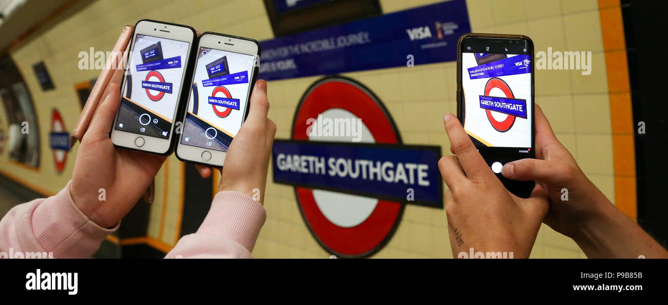 Southgate Stazione della Metropolitana. A nord di Londra. Regno Unito 17 luglio 2018 - Tre persone prendere una fotografia sui cellulari del segno. Locali, nazionali e internazionali di persone visitano il Southgate stazione della metropolitana prendere le fotografie del nuovo segno che è stato fatto in onore di England football manager, Gareth Southgate come England Football Team nazionale finito al quarto posto nella Coppa del Mondo in Russia. Il segno che sostituisce "outhgate' oltre i trasporti di Londra il logo è per solo 48 ore. Credito: Dinendra Haria/Alamy Live News Foto Stock