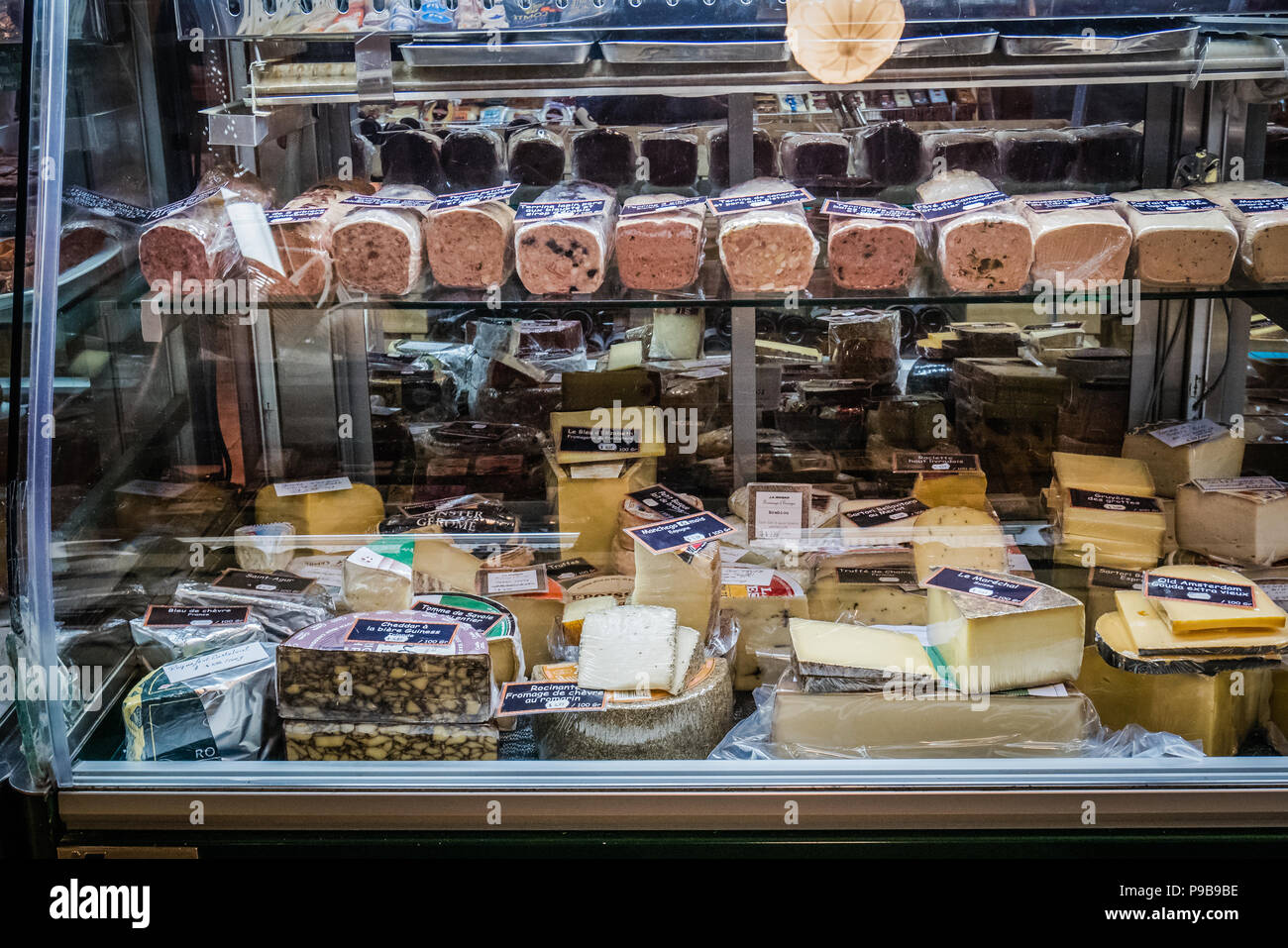 La carne e i formaggi la selezione all'interno di un piccolo negozio di alimentari Foto Stock
