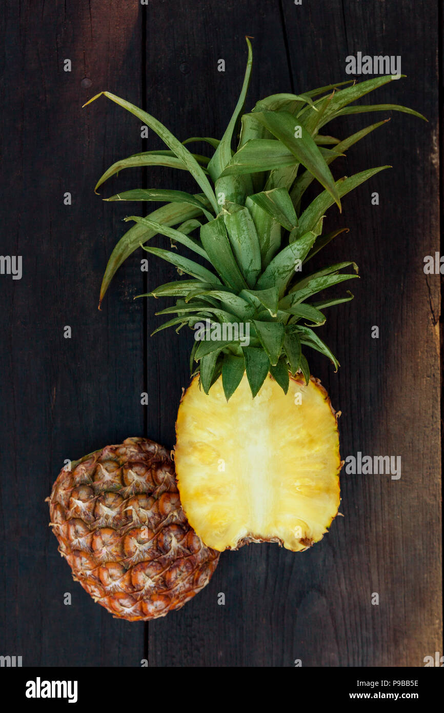Ananas fresco tagliato a metà dal di sopra su un tavolo di legno. Foto Stock