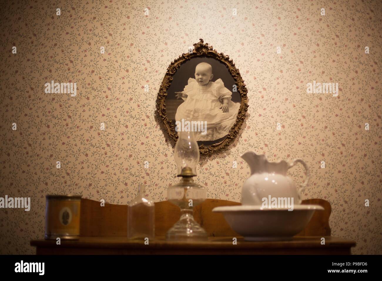 Un vecchio incorniciato fotografia di un bambino e di oggetti di antiquariato su un tavolo, presso il Museo di Springfield in Springfield, Oregon, Stati Uniti d'America. Foto Stock