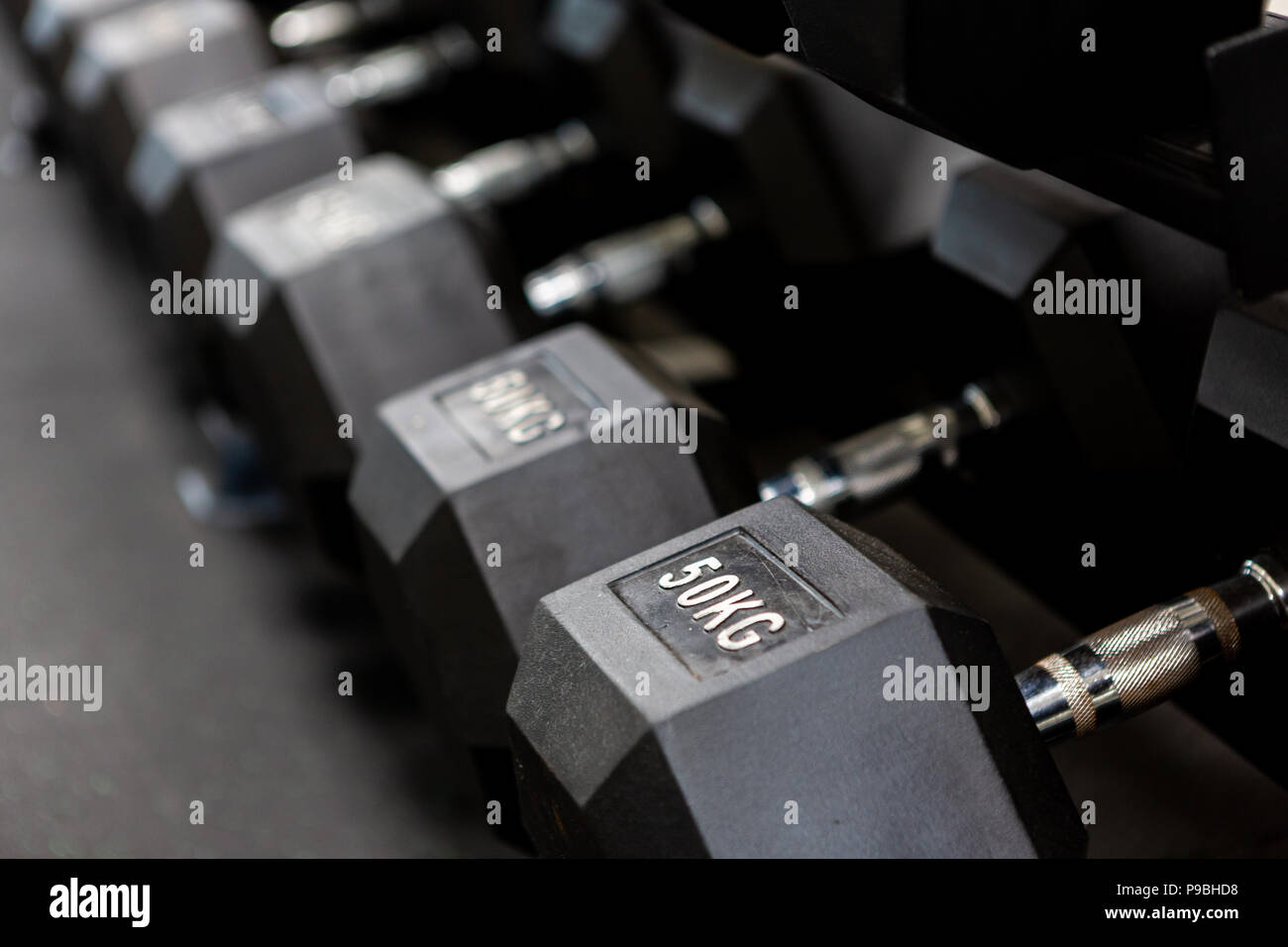 Una fila di manubri con rack con una messa a fuoco selettiva Foto Stock