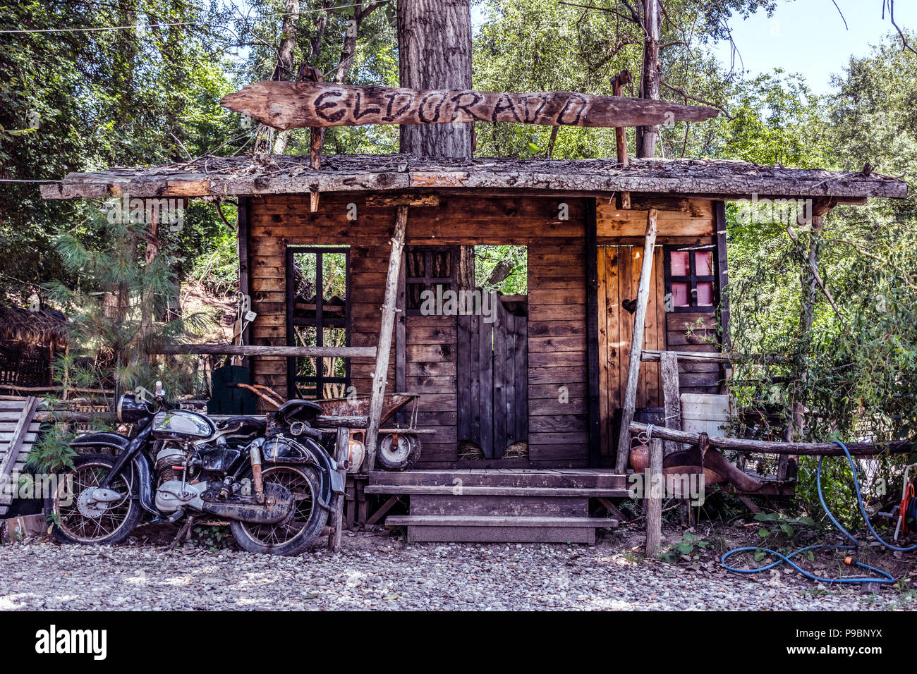 Nis, Serbia - Luglio 11, 2018: grande modello del Wild West saloon e vecchia motocicletta davanti alla casa in natura. El Dorado testo sul tavolato in legno Foto Stock