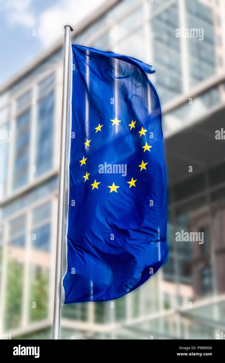 Bandiera dell'Unione europea soffia nella parte anteriore di un edificio per uffici Foto Stock