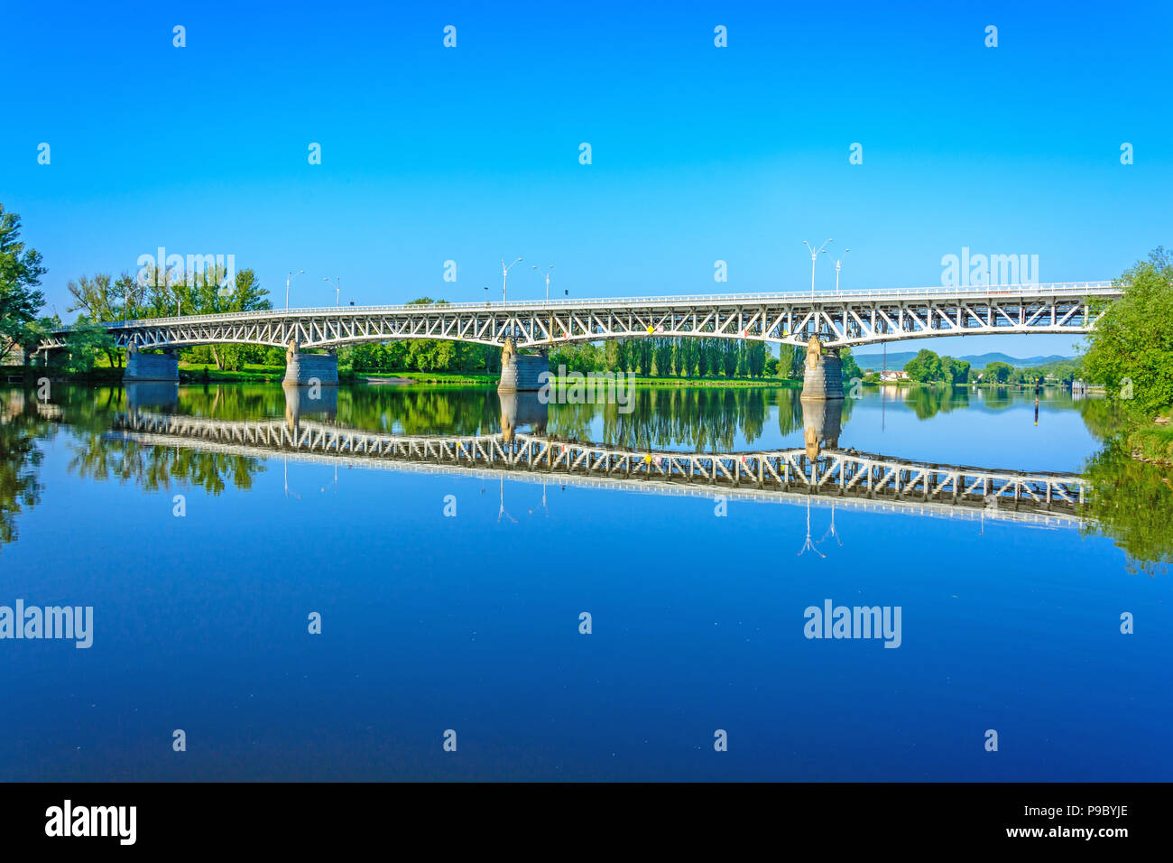 Acciaio ponte sopra il fiume Labe in Litomerice. La riflessione del ponte sul fiume. Alba sul fiume Elba Foto Stock