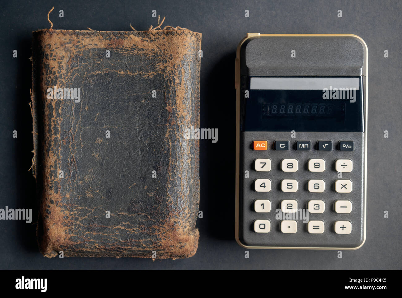 Vista della calcolatrice e pelle su sporco nero lo sfondo della carta. Foto Stock