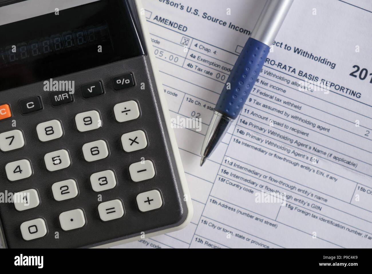 Vista della calcolatrice sul tavolo con i documenti fiscali. Foto Stock