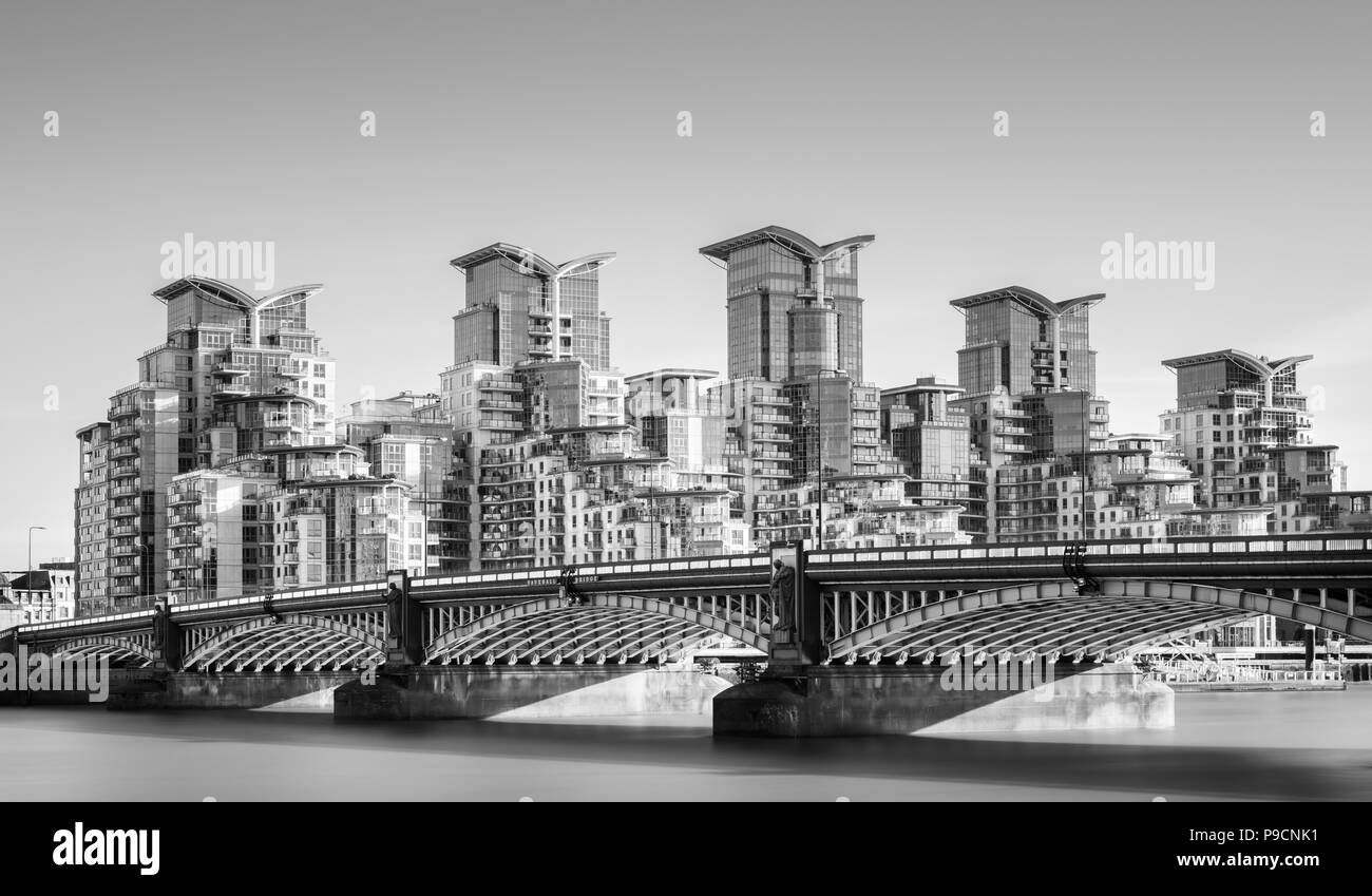 Una lunga esposizione del Fiume Tamigi a Vauxhall Bridge, Londra, con St George Wharf sistemazione ed edifici per uffici set contro un cielo privo di nuvole Foto Stock