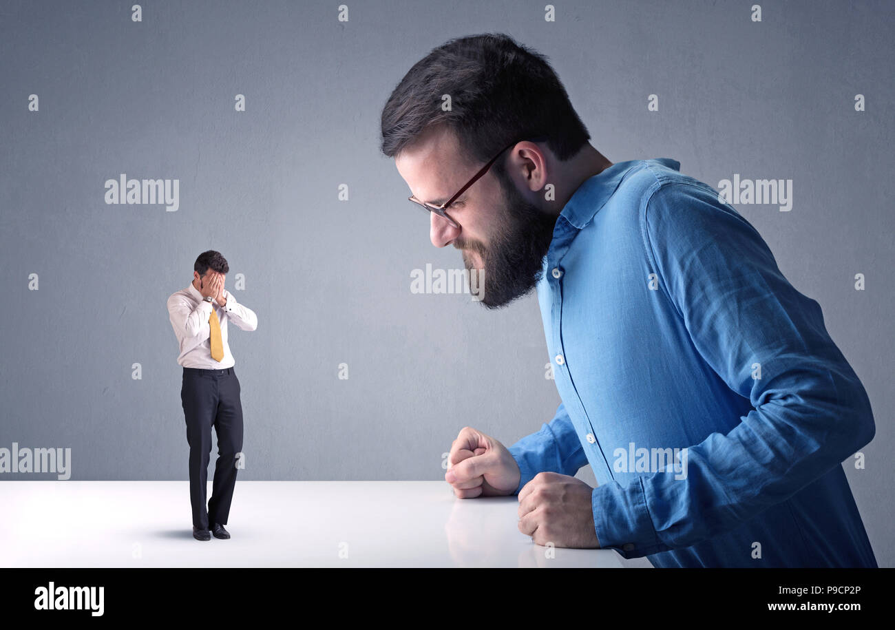 Giovane imprenditore professionale essendo arrabbiato con un altro imprenditore in miniatura Foto Stock