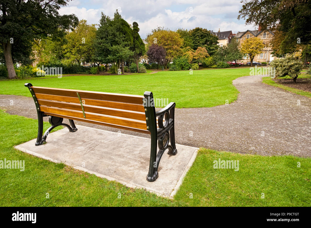 Una panchina nel parco in un piccolo parco urbano con giardini paesaggistici presso Regent Square, Doncaster, South Yorkshire, Inghilterra, Regno Unito Foto Stock