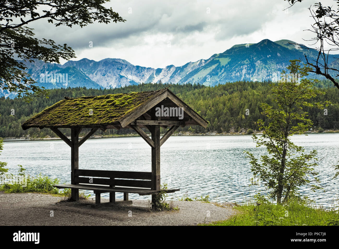 Lago Eibsee nelle Alpi Bavaresi, Baviera, Germania con piccolo banco coperto a riva Foto Stock