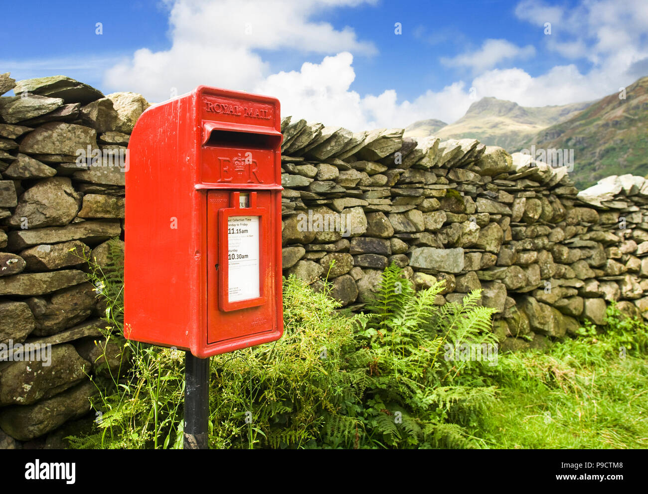 Rosso rurale Royal Mail post letter box e pietre a secco muro in una remota parte del Parco nazionale del Lake District, Cumbria, Inghilterra rurale, REGNO UNITO Foto Stock