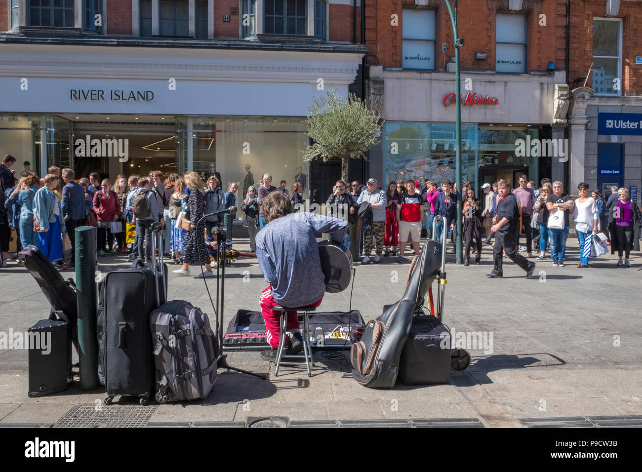 Un busker musicista,con una folla di persone che guardano il performer di Grafton Street, Dublin, Irlanda, Europa Foto Stock