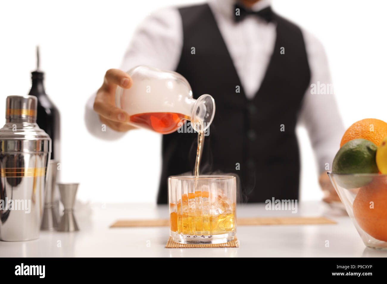 Barista colata di whiskey in un vetro isolato su sfondo bianco Foto Stock